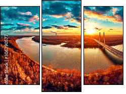 Beautiful panoramic aerial drone view to cable-stayed Siekierkowski Bridge over the Vistula river and Warsaw City skyscrapers, Poland in gold red autumn colors in November evening at sunset - Three-piece canvas, Triptych
